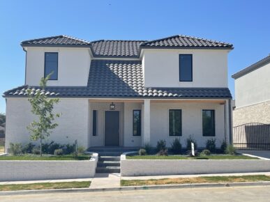 The exterior of a home with a white roof and gray siding.