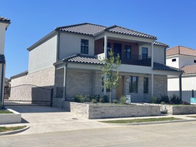 Two homes with a fence in front of them.