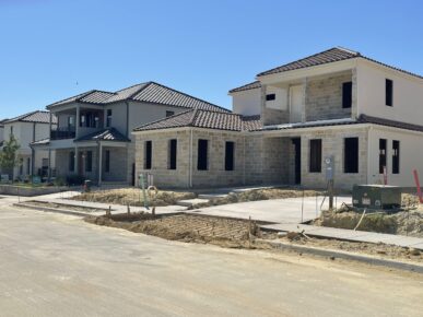 A group of homes under construction in a neighborhood.