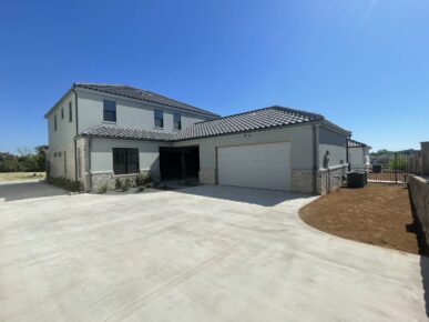 A home with two garages and a driveway.