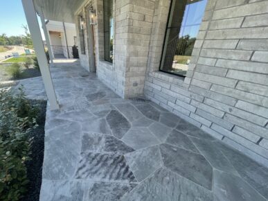 A stone walkway in front of a house.