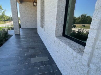 A walkway with black and white tile and a window.