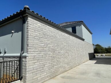 A house with a brick wall and a railing.