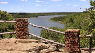 A wooden fence with a view of a river.