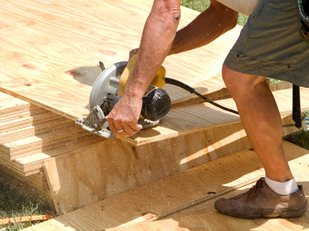 A man using a circular saw. A man using a circular saw.