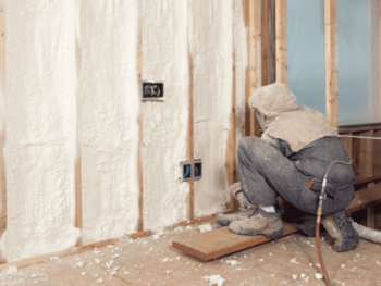 A man is working on a wall with insulation.
