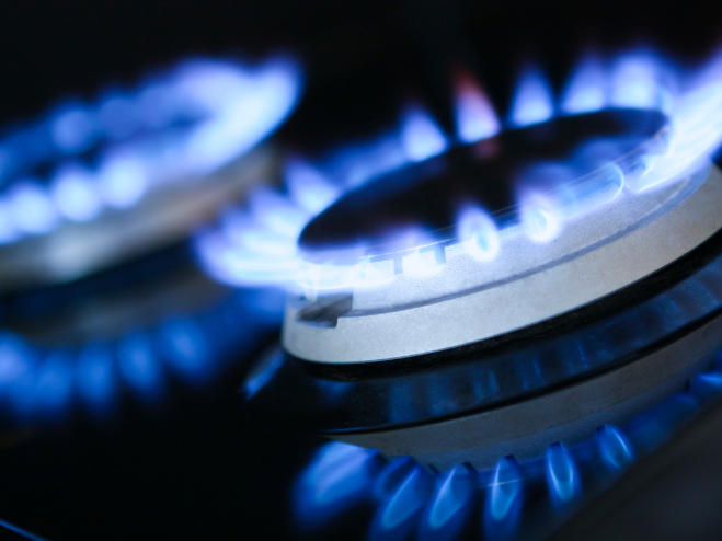 A close up of a gas stove with blue flames. A close up of a gas stove with blue flames.