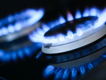 A close up of a gas stove with blue flames.